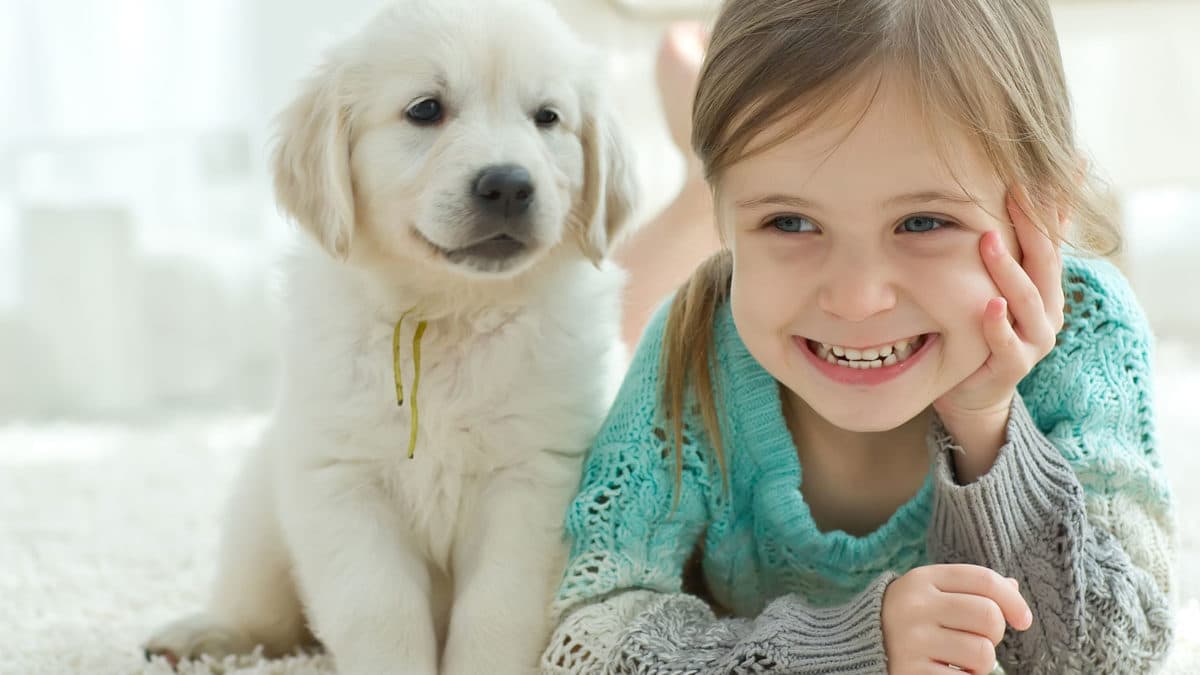 A girl with a dog on the carpet